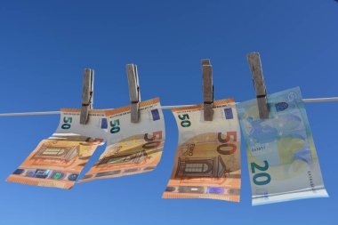 Yaratıcı kavram, para aklama. Avro banknotları kurumaya bırakılmış, rüzgarda savruluyor.