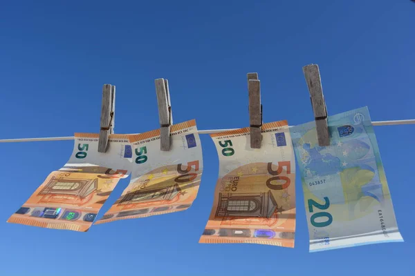 Yaratıcı kavram, para aklama. Avro banknotları kurumaya bırakılmış, rüzgarda savruluyor.