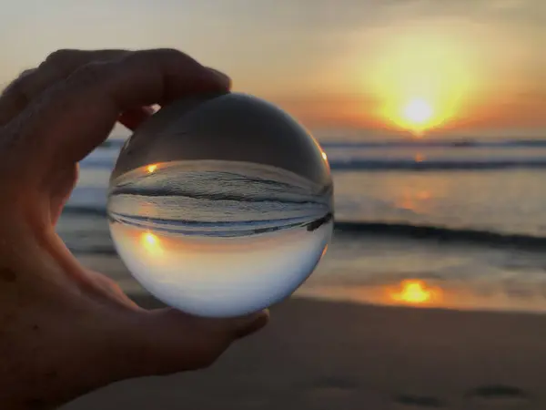 Dream Holiday concept. Looking through lens to a beautiful sunrise over sea from beach
