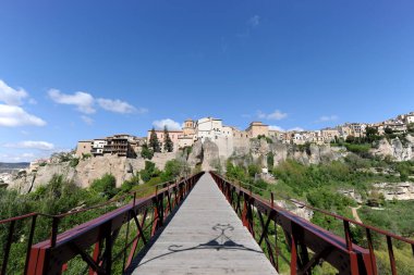 Huecar Nehri 'nin kıyısındaki köprüde Cuenca, Astilla La Mancha, İspanya' nın ünlü asma evleri Casas Colgadas ve Old Town 'a bakılıyor.