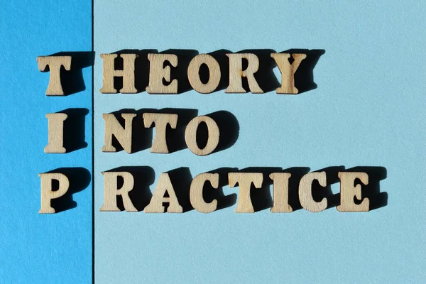 TIP, acronym for Theory Into Practice in wooden alphabet letters isolated on blue background