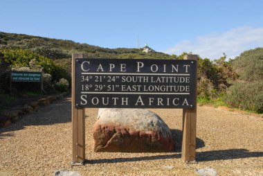 Cape Point, Cape Town, Güney Afrika. Cape Point tabelası arkadaki Cape Point Deniz Feneri ile boylam ve enlem gösteriyor.