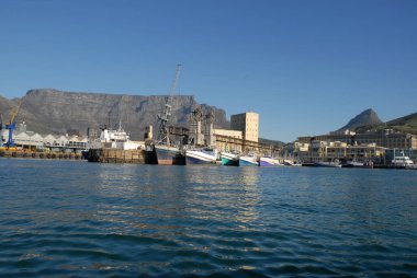 Cape Town Limanı, ticari rıhtımlar ve balıkçı tekneleri ve arka planda Masa Dağı, Batı Burnu, Güney Afrika 