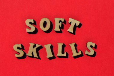 Yumuşak beceriler, kırmızı arkaplanda izole edilmiş tahta alfabe harflerindeki kelimeler.