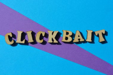 Clickbait, word in wooden alphabet letters isolated on colourful background as banner headline clipart