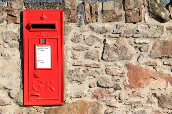 stock image Red post mail box in stone wall is Scotland, copy space on the right