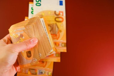  Burgundy 'nin arka planında euro banknotları var. Avrupa ülkelerindeki giderler ve gelirler. Avro parası. Paranın yeniden hesaplanması. Nakit ödemeler ve harcamalar. 