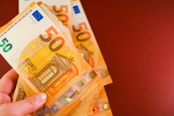 Banknoty Euro Ręku Banknoty Euro Ręku Bordowym Tle Wydatki Dochody — Zdjęcie stockowe