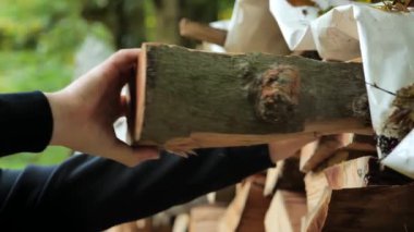 Yakacak odun. Isınma mevsimi. Katı yakıt. Erkek eller odunluktan odun topluyor. Yüksek kalite 4k görüntü
