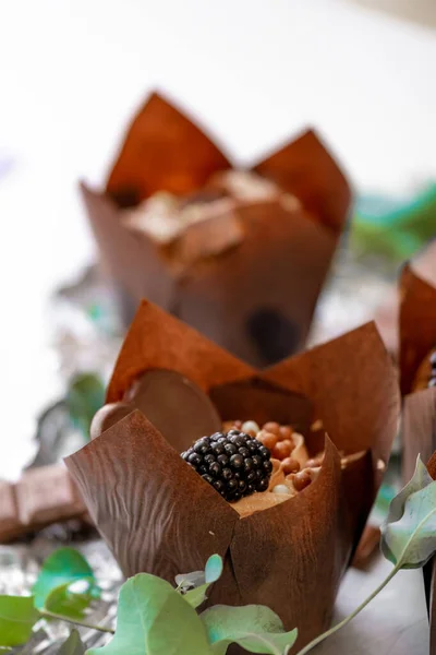 チョコレートデザート チョコレートカップケーキ ブラックベリーとユーカリの葉でマフィンを食欲をそそります 甘いテーブルを並べ替え スイーツとデザート 焼き菓子 — ストック写真