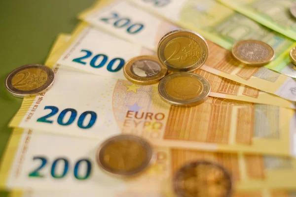 stock image Finance and savings. euro coins and Two hundred euro banknotes on a dark green background.Expenses and incomes in European countries. Cash payments and expenses.Euro currency.