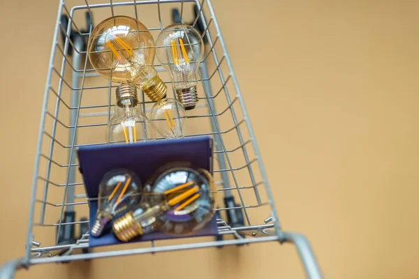 Verbruik Betaling Voor Energieverbruik Lampjes Een Supermarkttrolley Beige Achtergrond Aankoop — Stockfoto