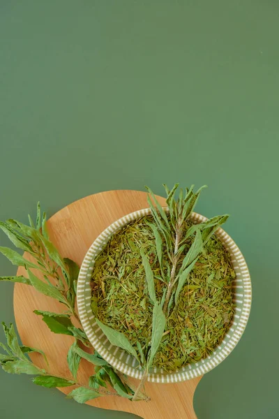 代替低カロリー野菜甘味料 オリーブの背景に丸いカップに乾燥ステビアと緑の小枝 天然の甘味料 — ストック写真
