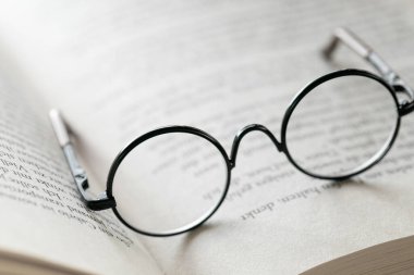 Reading glasses close-up on the pages of a book .Symbol of study, knowledge and reading.Reading concept.Education and schooling 