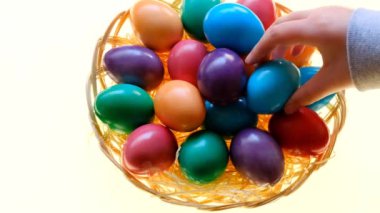 Easter eggs.hand puts an egg in a basket with painted eggson a white background. Easter food. Spring religious holiday symbol. Easter tradition.4k footage