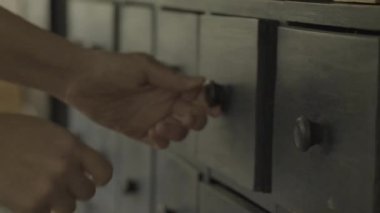 Search for a lost item.Search, loss, missing item concept. Hands pulling out chest of drawers in a blurry dark room.slow motion.Cleaning the closets. Woman looking in closet drawers. 4k footage