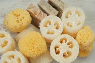  Hygiene products.reasonable consumption.Natural cognac sponges and loofah washcloths on a wooden white shabby board.Hygiene and health concept.Eco friendly bio natural cosmetics.
