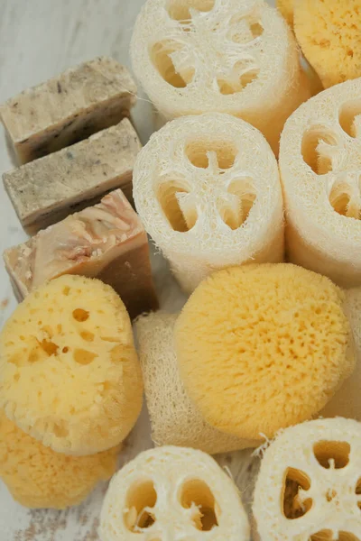 Zero waste Hygiene products set.reasonable consumption. Natural cognac sponges and loofah washcloths on a wooden white shabby board.Eco friendly bio natural cosmetics. 