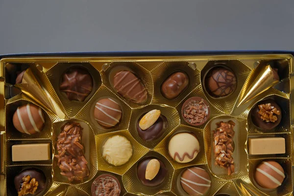 chocolate candies in a box on a gray background. Chocolate box. Milk chocolate candy.Sweets and desserts.