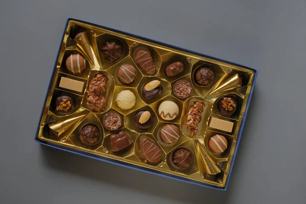 Milk chocolate candy.Sweets and desserts. Assorted chocolate candies in a box on a gray background. Chocolate box. Sweets box in assortment
