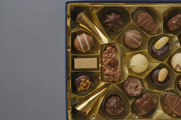 Chocolate box. Assorted chocolate candies in a box on a gray background. Milk chocolate candy.Sweets and desserts.Sweets box in assortment