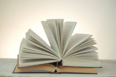  Reading books.Open books on a light background with a yellow gradient.stack of books on a wooden table.Learning and knowledge symbol.Reading and education.Literature and reading concept.