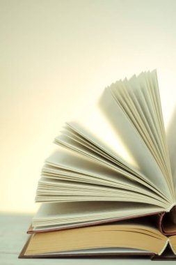 Literature and reading concept. Reading books.Open books on a light background with a yellow gradient.stack of books on a wooden table.Learning and knowledge symbol.Reading and education.