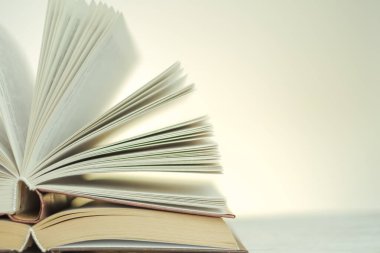 Reading and education. Open books on a light background with a yellow gradient.stack of books on a wooden table.Learning and knowledge symbol.Literature and reading concept. 