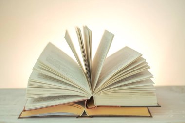  Reading books.Open books on a light background .stack of books on a wooden table.Learning and knowledge symbol.Reading and education.Literature and reading concept.