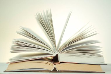  stack of books on a wooden table.Reading books.Open books on a light background with a yellow gradient. Learning and knowledge symbol.Reading and education.Literature and reading concept.