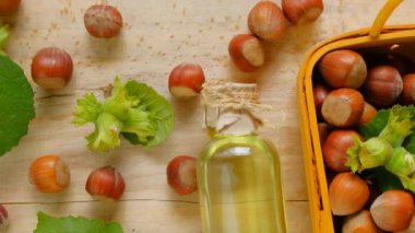 Hazelnut oil. bottle with oil in a yellow basket with ripe hazelnuts on a wooden table.Organic Vegan Products. View from above. Slow motion.4k footage
