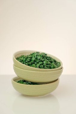 Spirulina pills In green cups set .Green spirulina tablets on green background.Spirulina algae tablets. Vitamins and dietary supplements.Super food .Food supplements for a healthy lifestyle