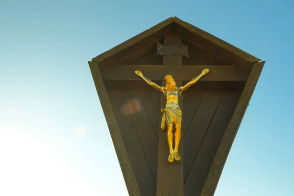 faith symbol. Jesus Christ on the wood cross on the blue sky with the rays of the sun. Christian and catholic faith symbol.Religious symbol.