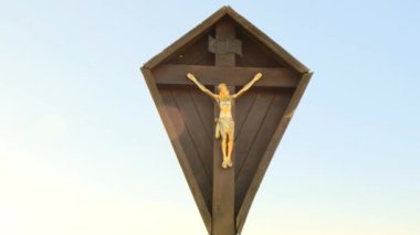 Jesus Christ on the wood cross on the blue sky with the rays of the sun. Christian and catholic faith symbol.Religious symbol. 4k footage