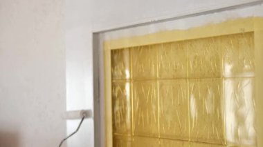 Home renovation inside.Construction roller for painting in the hands of a man.Redecorating.Door painting. Painting wooden surfaces. Construction and renovation concept. 4k footage