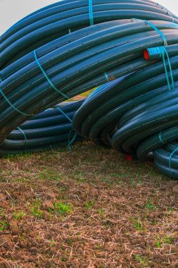 Tesisat tesisatı. Yeşil su boruları kapatılıyor. Yuvarlak plastik borular döşeniyor. Eve su getiriliyor.