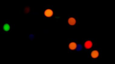 Işıldayan bokeh. Parıldayan ışıkları olan siyah duvar kâğıdı. Güzel bir arka plan. 4k görüntü