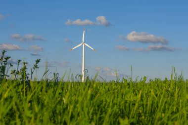Yeşil çimenlikteki rüzgar jeneratörü. Yenilenebilir enerji. Alternatif enerji kaynakları. Çevre dostu doğal enerji kaynağı.
