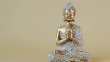 Bej arka planda Buda heykeli. Meditasyon sembolü. Budizm geçmişi. Sakin, denge ve uyum. 4k görüntü