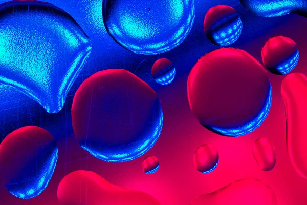 Bubbles in neon light.Fluid texture in pink and blue tones.drops wallpaper Blue and pink colors.neon phone wallpaper. Drops background texture with iridescent gradients.