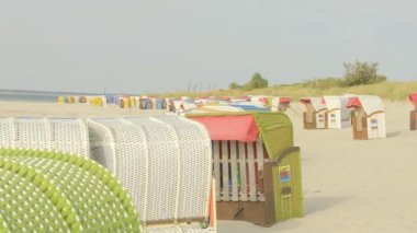 Deniz kıyısındaki plaj kulübesi. Denizde dinlen. Plaj hasır kutuları beyaz kuma kurulmuş. Fer Adası. Almanya. Kuzey Denizi. Hafif bir hava. Yaz tatilleri. Deniz tatili ve tatil.. 