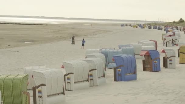 砂浜のビーチを歩く人 ファー島 ドイツのフリジア諸島 海のレクリエーションや休暇 城壁北海の砂の底に沿って歩く 4K映像 — ストック動画