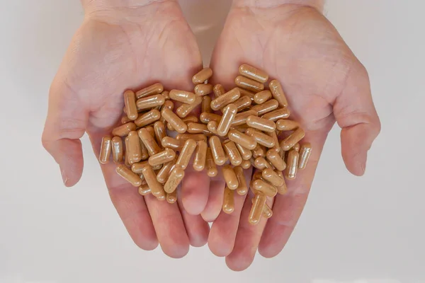 capsules with guarana powder. Guarana capsules in male hands on a white background. Natural tonic.Alternative medicine and homeopathy.Supplements and vitamins.Energy Biostimulator