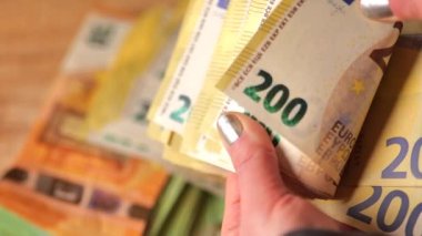 Para sayımı. 200 avro banknotlar. Avro banknotları sayılıyor. Eller banknotları yeniden hesaplıyor. Masraflar ve gelirler Avrupa ülkelerinde yeniden hesaplanıyor.. 