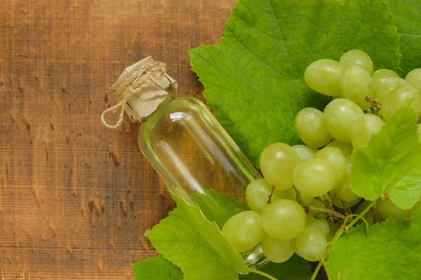 Flasche Traubenkernöl Und Grüne Trauben Auf Einem Hölzernen Hintergrund Kosmetisches — Stockfoto