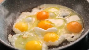 Kahvaltı için kızarmış yumurta. Protein kahvaltısı ayçiçeği yağında. Kahvaltı hazırlama süreci. Yağda yumurta. Sabahın köründe yumurtalarla kızartma tavası. 4k görüntü