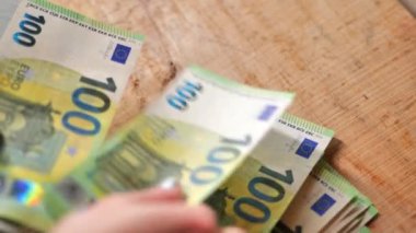 Para sayma. Tahta bir masa üzerinde 100 Euro 'luk banknotlar. Düşük hareket. Yüksek kalite 4k görüntü
