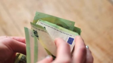 Para sayma. Tahta bir masa üzerinde 100 Euro 'luk banknotlar. Düşük hareket. Yüksek kalite 4k görüntü