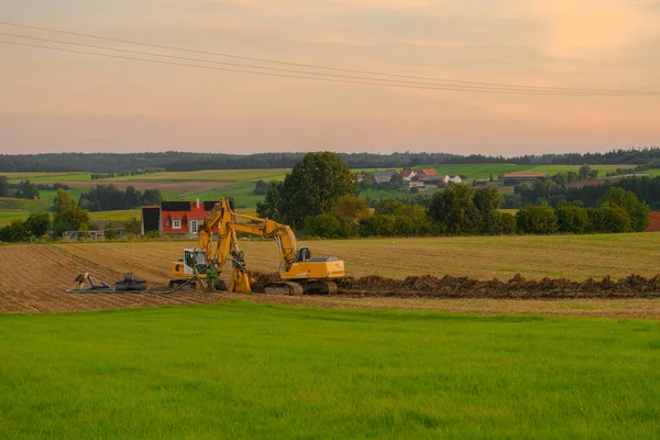Boru döşeme. Köyün arka planında kazıcılar var. İnşaat makineleri ve inşaat alanında çalışıyor. İletişim yürütülüyor.