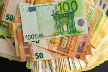 Para sayma. Siyah masanın üzerinde yüz elli euro banknot. Avro banknotları sayılıyor. Avrupa ülkelerindeki giderler ve gelirler. Paranın yeniden hesaplanması. 